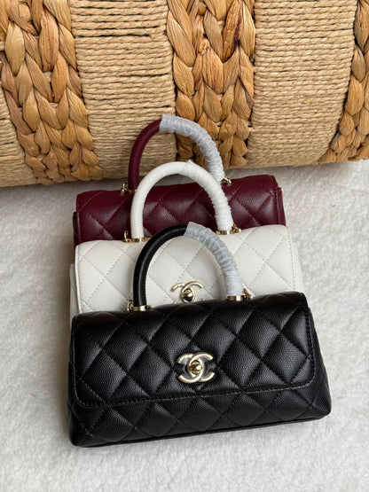 caviar leather Chanel Coco Handle Bag features a top handle